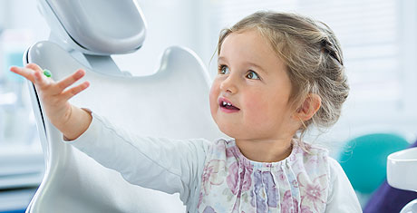 Kinder-Zahnheilkunde: Kind sitzt auf Zahnarztstuhl